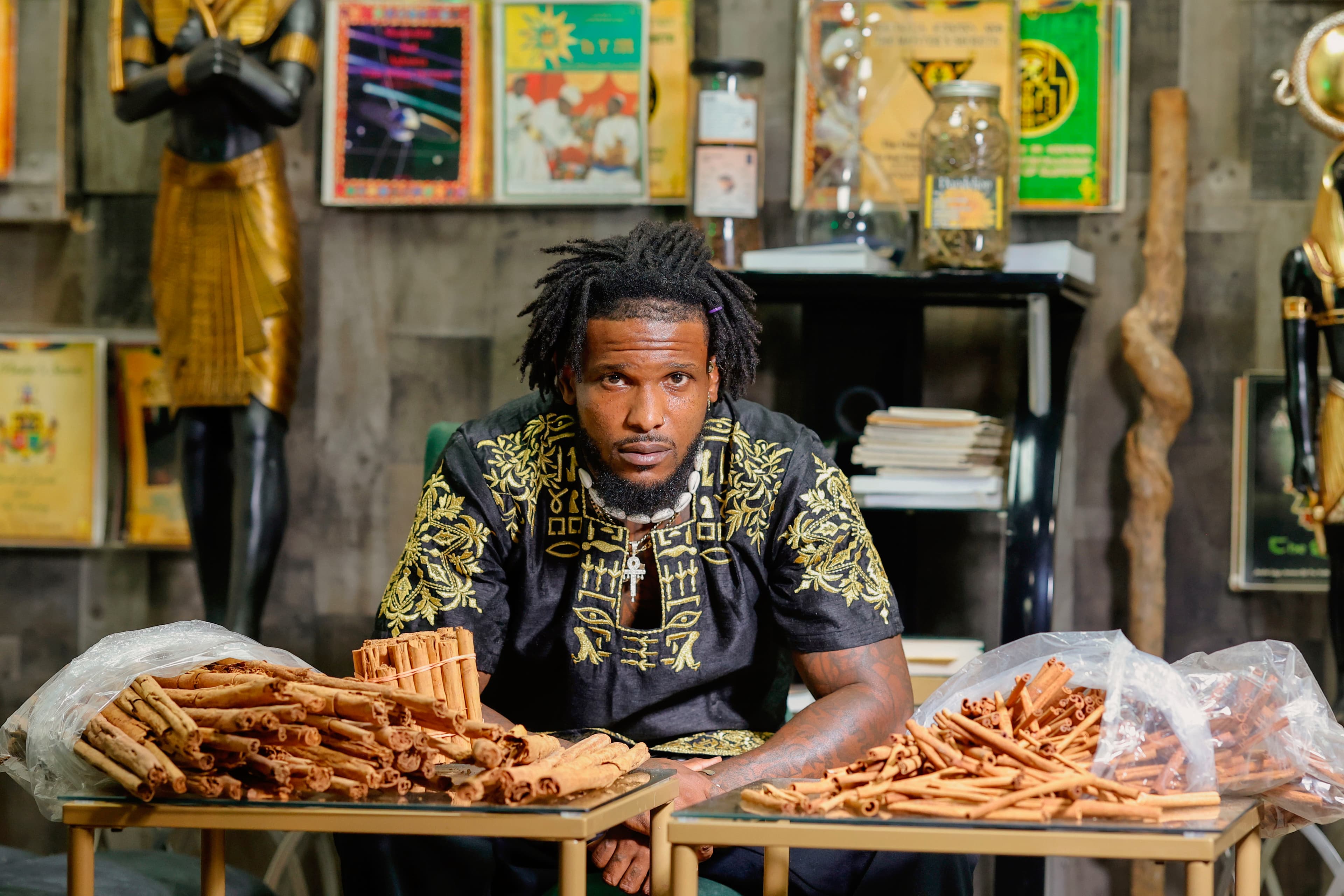 Kedar, founder of Divine Love Health Center, with cinnamon and herbal goods in the shop